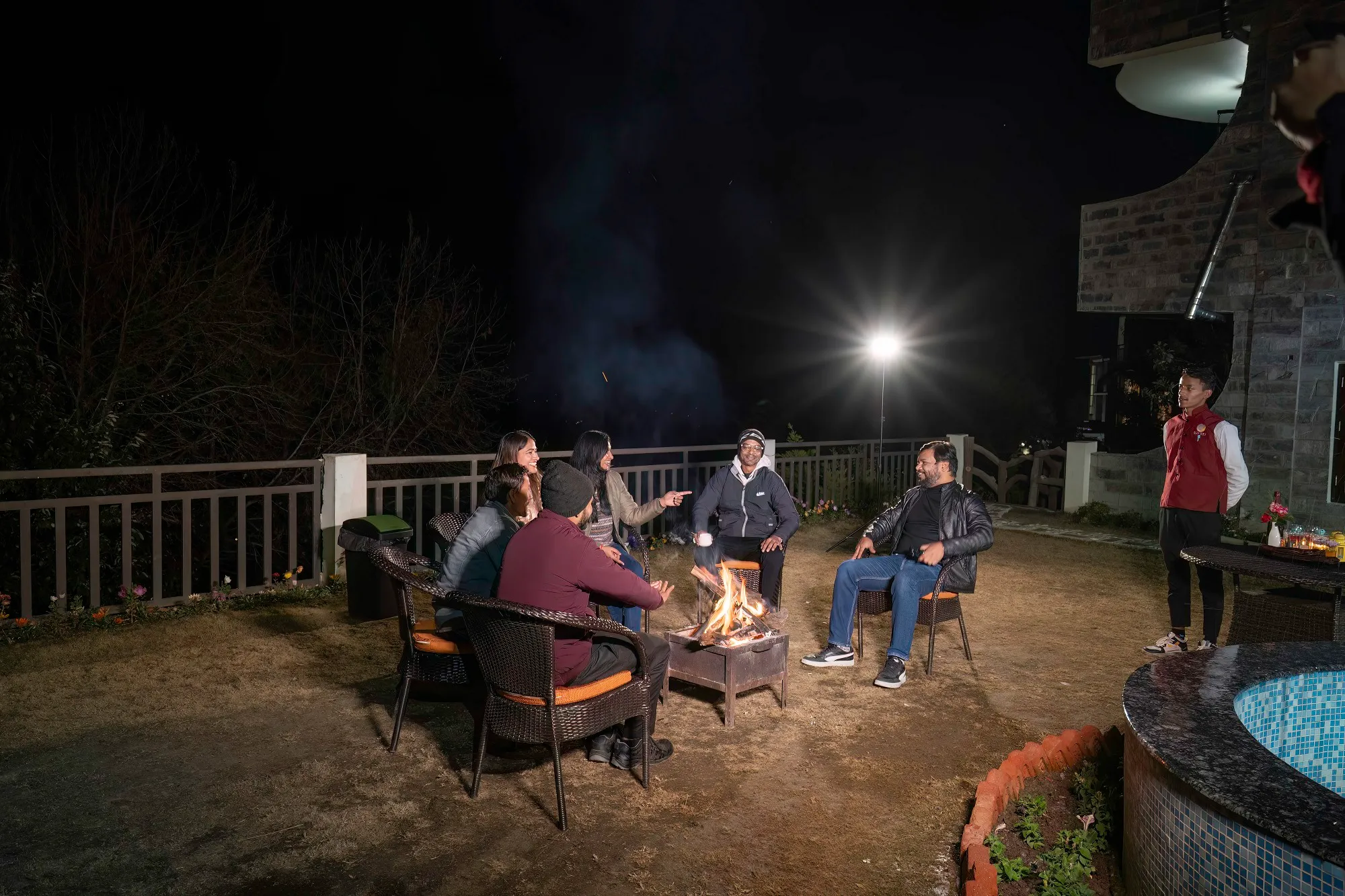 Guests enjoying a bonfire at Ojaswi Himalayan Resort in Mukteshwar