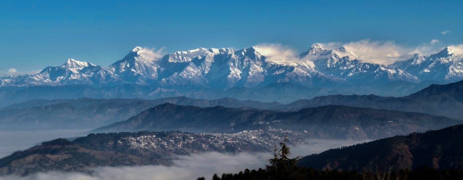 Beautiful stone architecture of Ojaswi Resort Mukteshwar, a premium hill escape with mountain-facing balconies.