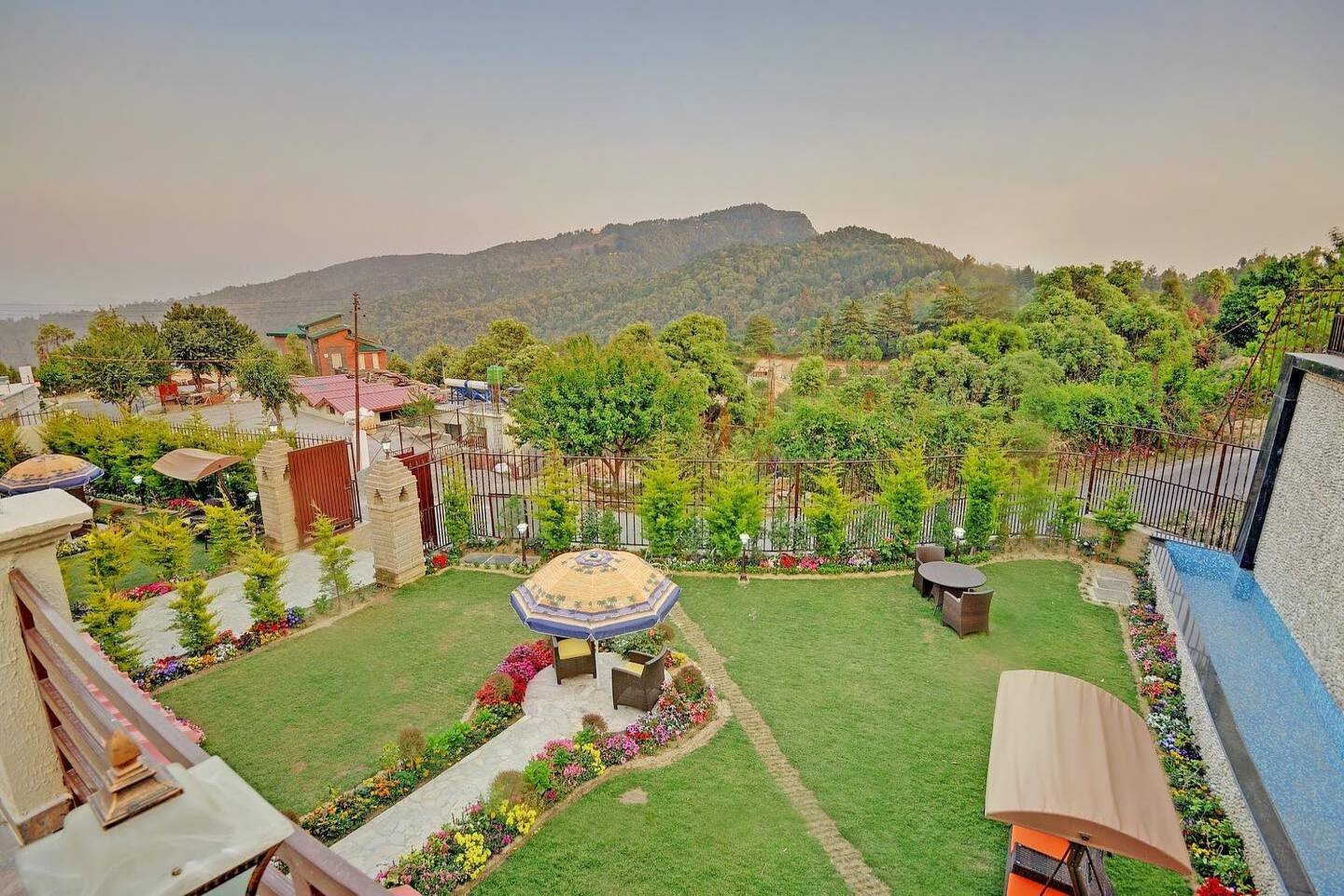 Lush green lawn and outdoor seating at Ojaswi Himalayan Resort, offering breathtaking mountain views in Uttarakhand.