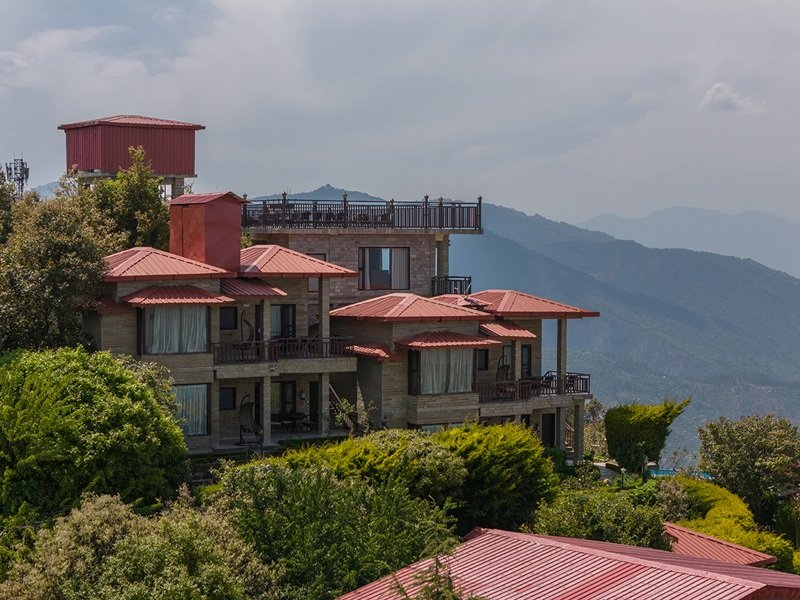 Beautiful stone architecture of Ojaswi Resort Mukteshwar, a premium hill escape with mountain-facing balconies.