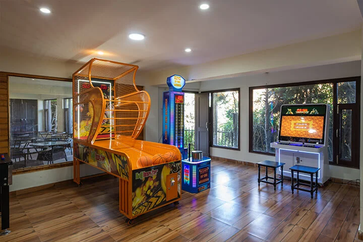 Indoor arcade game room at Ojaswi Resort featuring a basketball machine and punching game.