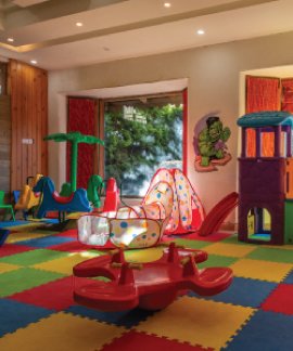A colorful indoor play area for young children, equipped with safe toys, slides, and soft mats.